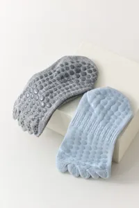 Close-up detail of non-slip five-toe yoga socks with silicone grips for pilates and sports.
