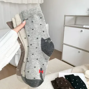 Chaussettes mi-mollet en laine avec motif chat et pois mignons dans des tons vintage.