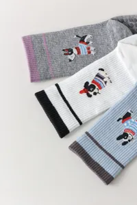 Close-up detail of cute cartoon dog knit non-slip socks, soft fabric and anti-skid grip sole.