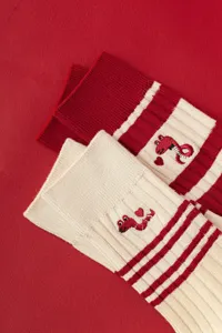 Red knitted women socks with cute snake embroidery and stripes, comfortable detail view.