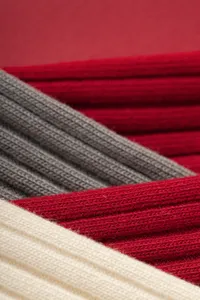 Close-up detail of soft ribbed knit fabric, showing fine texture and multi-color layered design.