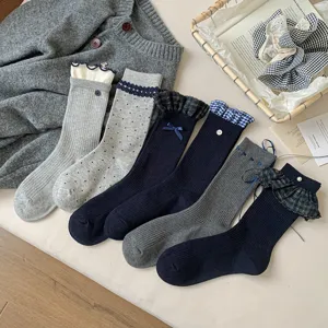 Detailed view of blue-grey women's mid-tube socks featuring cute ruffles, bows and lace.
