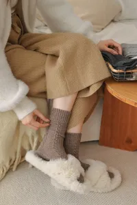 Primo piano di comode calze in lana a trecce che mostrano consistenza e comfort in casa.
