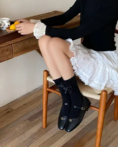 Detailed view of sweet black mid-tube socks featuring delicate lace bows, perfect for cute outfits.