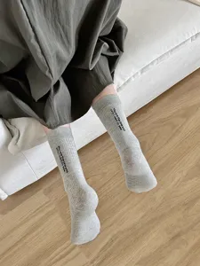 Primo piano di calzini in cotone a coste grigie con ricamo di testo inglese, morbidi.