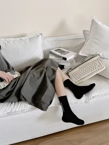 Vista dettagliata di calzini medi neri in cotone con ricamo di lettere bianche alla moda.