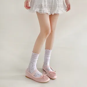 Detail shot of women's white lace hollow-out ruffled crew socks, lightweight and breathable.