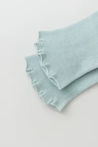 Close-up detail view of light green ribbed open toe yoga socks with split toe design.