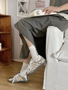 Comodi calzini di cotone con ricamo di lettere, abbinati a scarpe da ginnastica argentate.