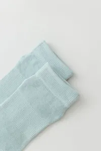 Light blue yoga socks detail view, breathable knitted texture for comfortable sports wear.