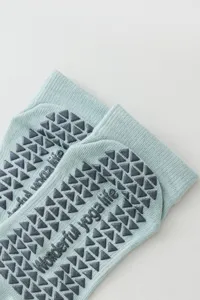 Non-slip yoga socks detail with grey silicone grip dots on sole for pilates and sports.