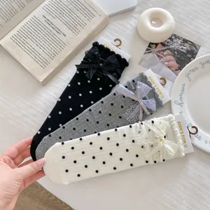 Cute polka dot mid-calf socks featuring delicate lace trim and sweet bows for daily wear.