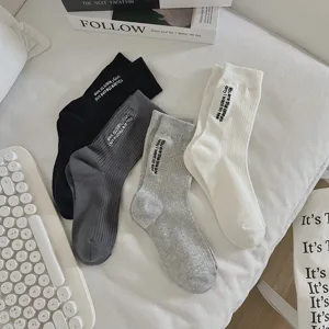 Vista dettagliata di calzini in cotone da donna con elegante ricamo di lettere in evidenza.