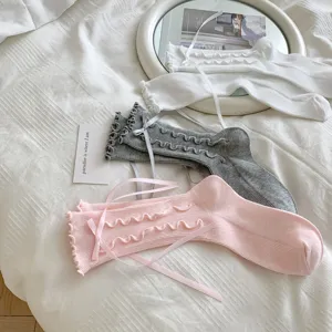 Details of cute Japanese JK style women mid-tube socks featuring delicate ruffles and sweet bow ribbons.