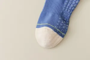 Nahaufnahme Detail von rutschfesten Yogasocken mit Grip-Noppen und blau-weißem Strick.