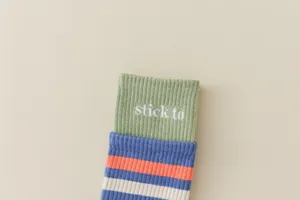 Nahaufnahme von gerippten Damen-Wadensocken mit bunten Streifen und gestricktem Schriftzug.