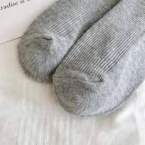 Grey ribbed knit socks detail view, showing fine vertical stripe texture and soft material.