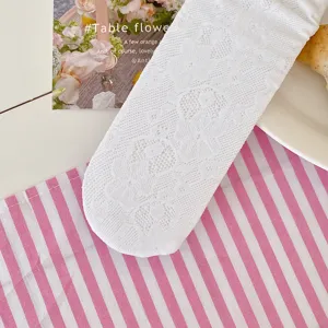Detail shot of white lace ballet socks with delicate floral hollow-out pattern and breathable knit.
