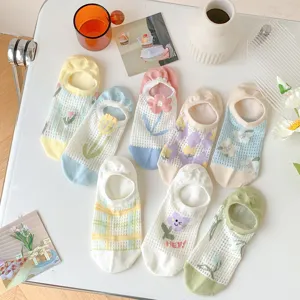 Detail shot of cute floral mesh boat socks neatly arranged with aesthetic lifestyle props.