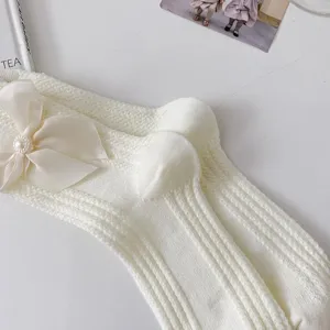 Chaussettes mi-mollet Lolita douces pour femme avec joli nœud et perle pour look kawaii parfait.