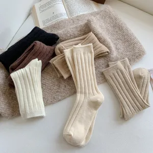 Detail view of cozy wool ribbed slouchy mid-tube socks in winter retro colors, soft knit.