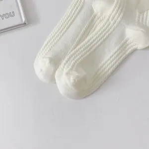 Vue détaillée de chaussettes mi-hautes lolita blanches avec un joli nœud pour uniformes.