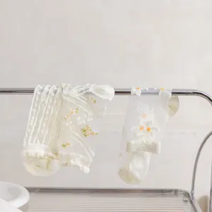Detailansicht weißer transparenter Blumen-Kristallstrümpfe, ultradünnes Mesh-Design für Sommer.