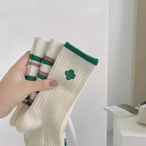 White mid-calf socks featuring green stripes and cute clover embroidery for women.