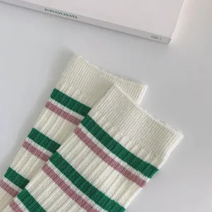 Close-up detail view of Japanese style college striped slouch socks in white green and pink.
