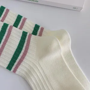 Green and pink striped mid-tube knit socks detail view, soft cotton texture for women