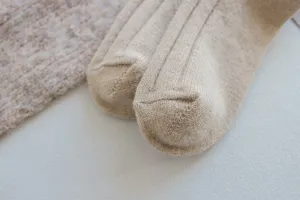 Close-up detail of cozy ribbed wool socks in camel color, showing soft texture and knit quality.