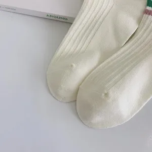 Detailed close-up view of white ribbed socks highlighting fine knit texture and stripes.