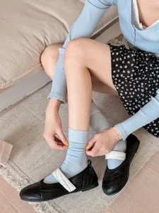 Light blue mid-calf split toe socks paired with stylish black Mary Jane flat shoes.