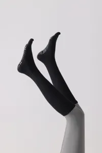 Detail shot of black non-slip five-toe yoga socks, featuring white grip dots for stability.