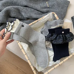 Detailed shot of cute Japanese style ruffle mid-calf socks with delicate lace and pearls.