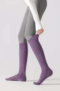 Detailed view of purple yoga toe socks with non-slip grips and ribbed knee-high design.