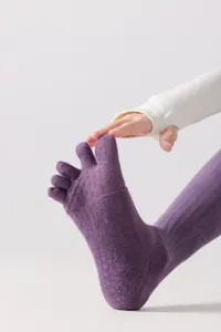 Close-up detail of purple five-toe yoga socks, featuring stretch fabric and split-toe design.