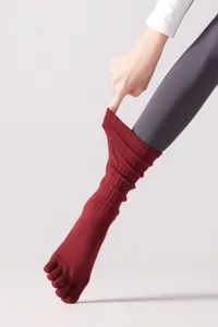Primo piano dettaglio calze yoga bordeaux a cinque dita con morbido tessuto lavorato a maglia.