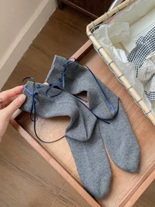 Grey women mid-tube socks with blue ribbon bows, sweet knit fashion socks for daily wear.
