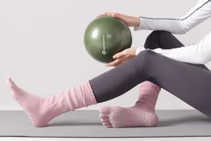 Vista dettagliata di calzini da yoga rosa a cinque dita con pallini antiscivolo per fitness.