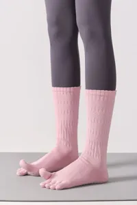 Vista dettagliata di calzini da yoga rosa a cinque dita con pallini antiscivolo per il fitness.