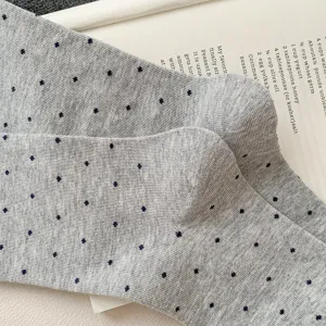 Close-up detail of grey polka dot knit mid-tube socks, soft fabric texture and cozy design.
