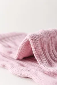 Vista macro dei dettagli della calza da yoga in maglia rosa, tessuto a coste morbido e comodo.