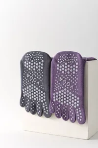 Detail shot of five toe yoga socks with non-slip grip dots on sole for pilates and sports.