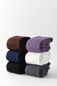 Detailed view of stacked ribbed long socks in multi-colors, soft knit fabric texture closeup.