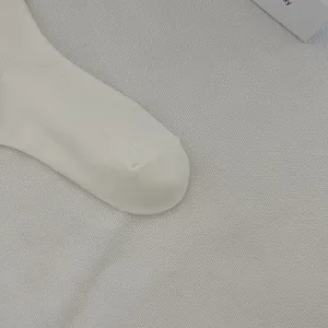 Dettaglio di calzini in cotone a costine bianco, stile a metà tubo casual per le donne.
