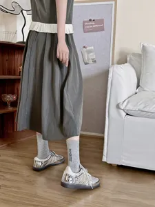 Calzini medi in cotone grigio con delicato ricamo di lettere e sneakers argento.