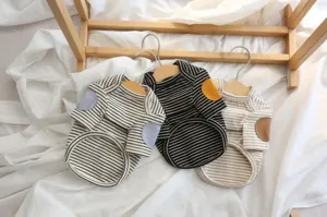 Close-up detail of striped pet sweater with cute elbow patches on miniature wooden hangers.