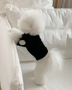 Close-up detail of a black pet knit sweater with white patch for small dogs like puppies.