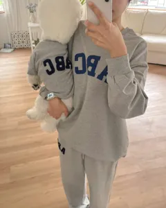 Detailed view of autumn winter matching pet and owner grey embroidered letter sweatshirts.